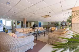 a waiting area with couches and tables in a room at BLUESEA Veril Playa in Playa del Ingles
