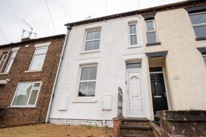 a house with a white door and a brick building at 3 BD 5 Beds WiFi in Wellingborough