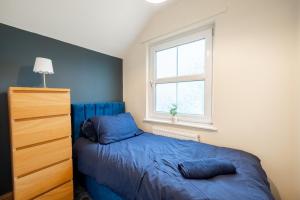 a bedroom with a blue bed and a window at 3 BD 5 Beds WiFi in Wellingborough