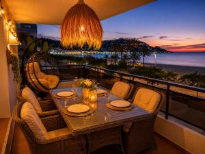 a table on a balcony with a view of the ocean at Roses Beach in Roses