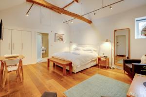 a bedroom with a bed and a living room at The Suites at Pannells Ash in Castle Hedingham