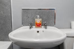 a white sink with a bottle of soap on it at 3 BD 5 Beds WiFi in Wellingborough +27 photos