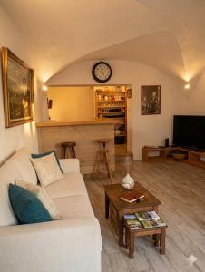 a living room with a white couch and a clock at Volca'séjour in Orcines