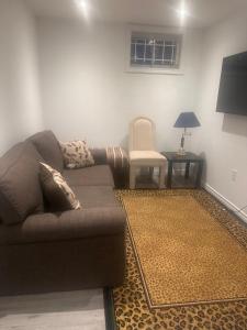 a living room with a couch and a chair at Mill pond cozy and private 2 in Richmond Hill
