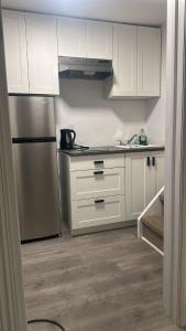 a kitchen with white cabinets and a stainless steel refrigerator at Mill pond cozy and private 2 in Richmond Hill