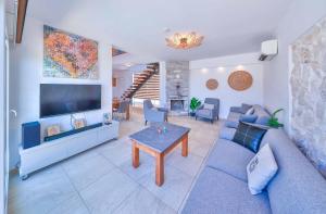 a living room with a blue couch and a tv at Nergiz Villas in Kaş