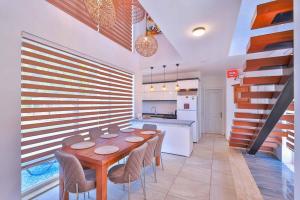 a dining room with a table and chairs and a kitchen at Nergiz Villas in Kaş