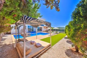 a bed with an umbrella next to a pool at Nergiz Villas in Kaş