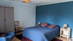 a bedroom with a blue bed and a chair at chambre d'hôte la Sourdrie in Saint-Florent-le-Vieil +14 photos