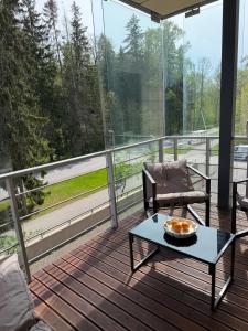 a balcony with a table and chairs on a deck at The Baltic Sea Hideaway in Narva-Jõesuu