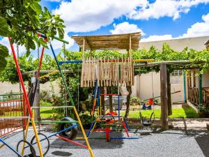 a swing set in a yard next to a house at Hazeldene Accommodation in Colesberg +2 photos