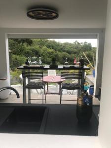 a kitchen with a table and two chairs and a patio at Le Clos de Bourgueil in Sainte-Anne