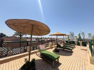 a group of chairs and umbrellas on a patio at Riad Douha in Marrakesh