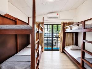 a room with three bunk beds in a hostel at Sunset Seaview Bay Villa in Putatan