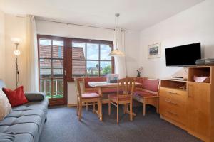 a living room with a table and chairs and a television at Haus Baden in Hagnau