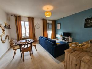 a living room with a blue couch and a table at Quai de la Gare, Appartement étape, 2 chambres, face à la Gare in Châtellerault