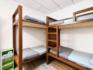 a room with three bunk beds in a dorm room at Sunset Seaview Bay Villa in Putatan
