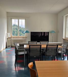 a room with tables and chairs and a flat screen tv at Marienburg Castle in Wikon