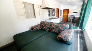 a green couch in a room with a kitchen at Casa Verde in Limeira