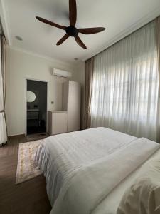 a bedroom with a bed and a ceiling fan at Elite Cozy Home 5BR5B, BBQ, Karaoke, Netflix, Near MITC in Ayer Keroh