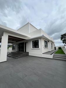 a large white house with a large driveway at Elite Cozy Home 5BR5B, BBQ, Karaoke, Netflix, Near MITC in Ayer Keroh