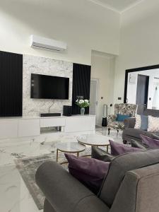 a living room with a couch and a tv at Elite Cozy Home 5BR5B, BBQ, Karaoke, Netflix, Near MITC in Ayer Keroh