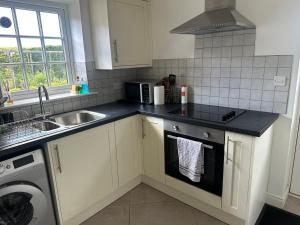 a kitchen with a sink and a stove top oven at The Studio in Willerby +3 photos