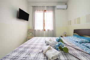 a bedroom with a bed with towels on it at Piccola Casa Melis in Capoterra