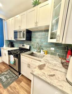 a kitchen with white cabinets and a sink and a stove at Chicago Coach Casa in Chicago