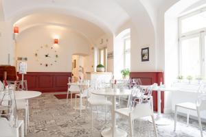 a dining room with white tables and white chairs at Hotel Garden Court in Prague