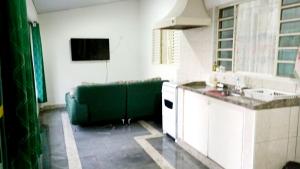 a kitchen with a green couch in a room at Casa Verde in Limeira +12 photos