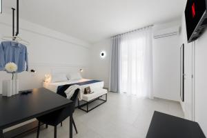 a white bedroom with a bed and a desk at Sea View Hotel Fronte Mare in San Vito lo Capo +24 photos