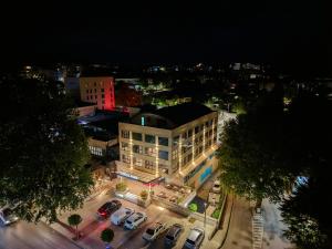 a building with cars parked in a parking lot at night at Hotel Park in Široki Brijeg +10 photos