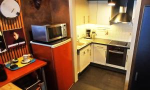 a small kitchen with a microwave and a sink at B2B Apartment Creamundi in Lokeren