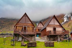 a group of houses with a mountain in the background at Kazbegi 4 side cottages in Kazbegi