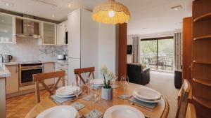 a kitchen and dining room with a table and chairs at Wansfell Cottage At Windermere Marina Village in Bowness-on-Windermere
