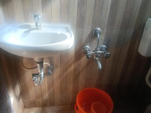 a white sink in a bathroom with wooden walls at crown crest condos in Chengalpattu