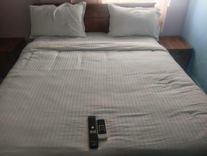 two remote controls sitting on top of a bed at crown crest condos in Chengalpattu