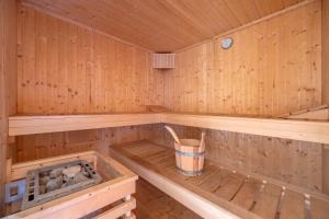 a inside of a wooden sauna with a bucket in it at Reethus am Küstenwald in Koserow +30 photos