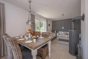 a dining room with a table and chairs and a living room at Reethus am Küstenwald in Koserow