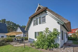 a white house with a roof at Reethus am Küstenwald in Koserow