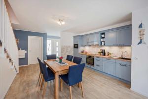 a kitchen with a wooden table and blue cabinets at Usedom-Idyll in Loddin