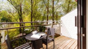 a balcony with a table and chairs on a deck at Wansfell Cottage At Windermere Marina Village in Bowness-on-Windermere