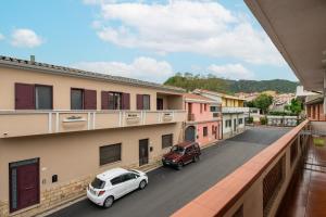 a city street with two cars parked on a balcony at Piccola Casa Melis in Capoterra