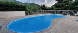 a blue swimming pool in a yard with a fence at Gîte Le Devant De La Chaux in Pontaix
