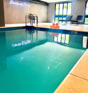 een zwembad met blauw water in een gebouw bij Hotel Wapen van Delden in Delden