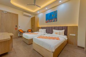 a hotel room with two beds and a desk at Mosaic Connect Ayodhya in Ayodhya +17 photos