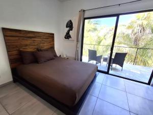 a bedroom with a large bed and a large window at Casa Pavezin in Mahahual