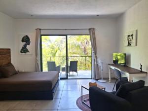 a bedroom with a bed and a desk and a living room at Casa Pavezin in Mahahual