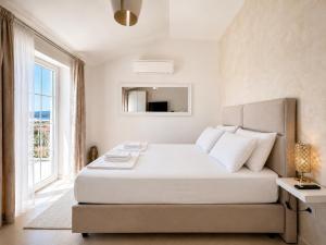 a white bedroom with a bed and a window at Orebic Luxury Villa Leopold in Orebić +11 photos